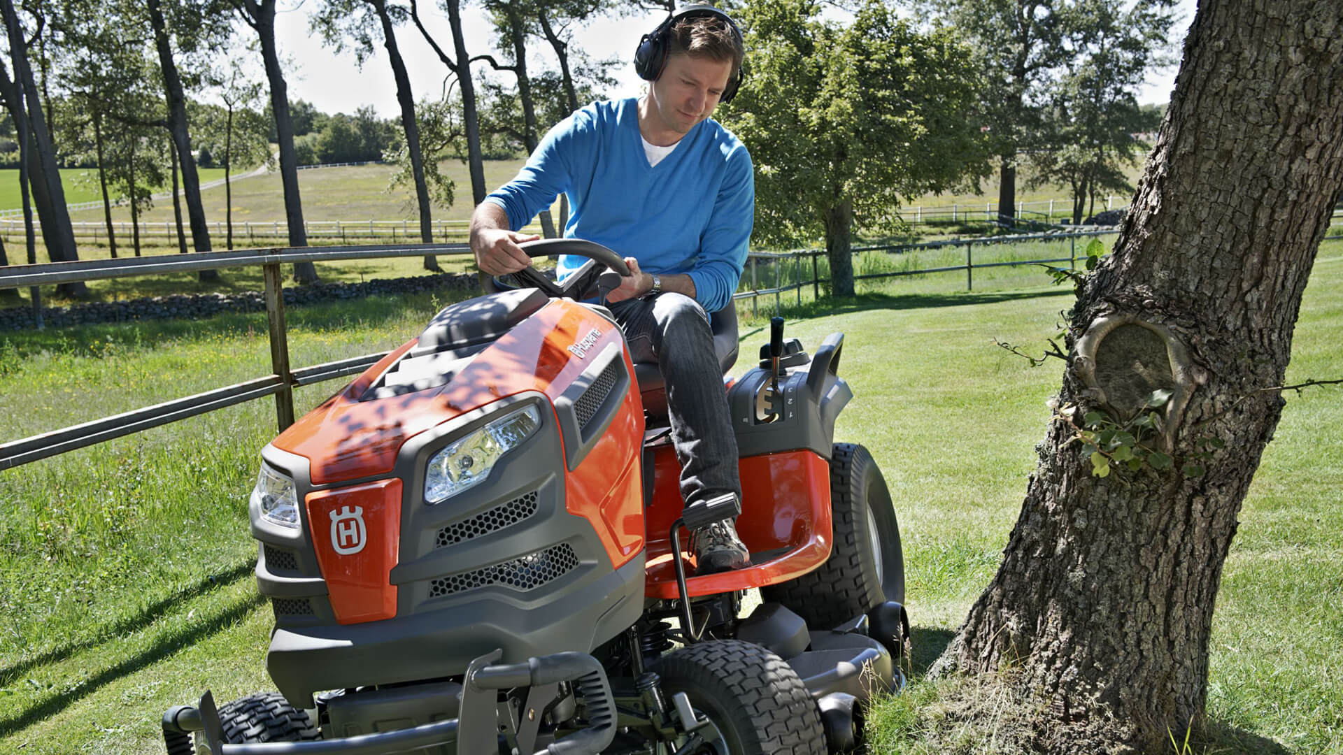 Uomo che taglia l'erba del giardino con un prodotto Husqvarna